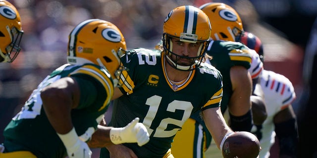 Green Bay Packers quarterback Aaron Rodgers (12) hands the ball off to running back A.J. Dillon Sunday, Oct. 17, 2021, in Chicago.