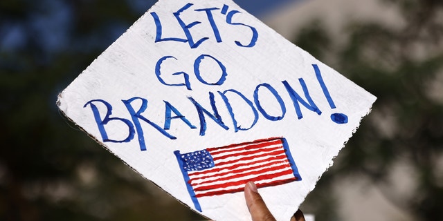 A protestor holds a 'Let's Go Brandon!' sign in Grand Park at a ‘March for Freedom’ rally demonstrating against the L.A. City Council’s COVID-19 vaccine mandate for city employees and contractors on November 8, 2021 in Los Angeles, California.  (Photo by Mario Tama/Getty Images)