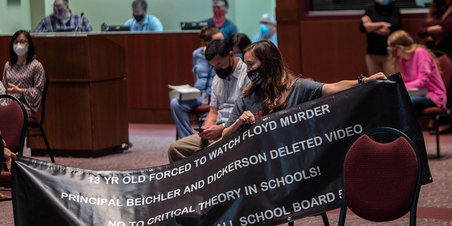 A woman holds up her sign against Critical Race Theory (CRT) being taught during a Loudoun County Public Schools (LCPS) board meeting on October 12, 2021.