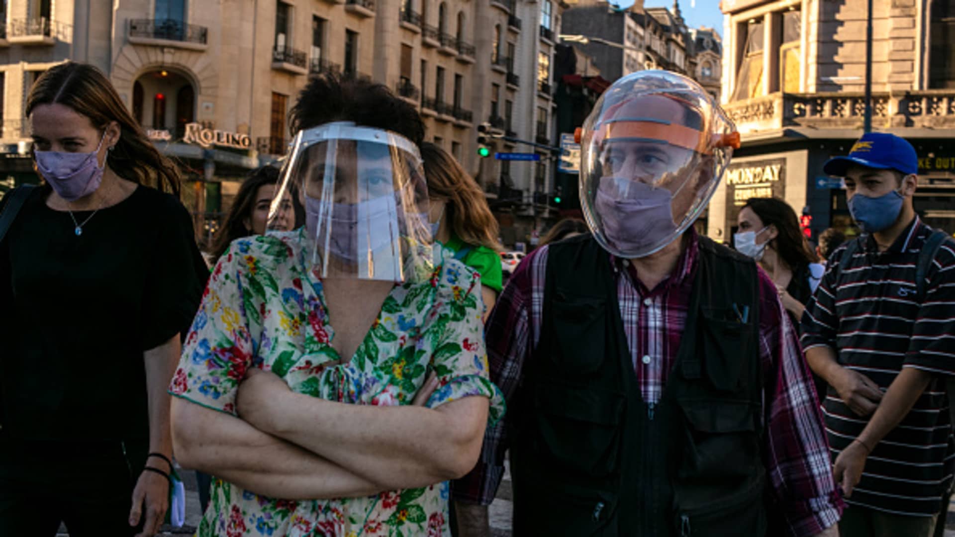 A couple with protective masks walk on a street amid a new surge of Covid-19 cases as the Omicron variant spreads on December 28, 2021, in Buenos Aires, Argentina.