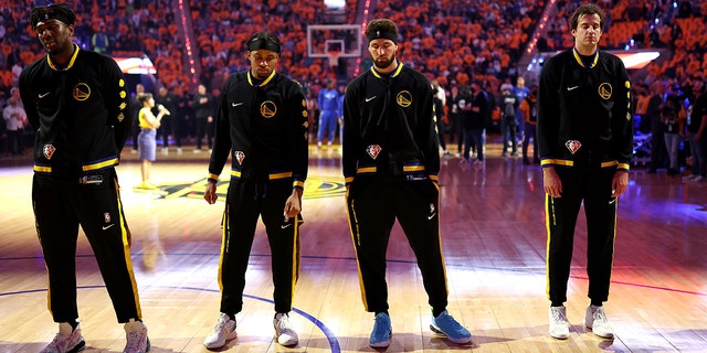 Kevon Looney, Moses Moody, Klay Thompson and Nemanja Bjelica of the Golden State Warriors stand for a moment of silence for the victims of the mass shooting at Robb Elementary School in Uvalde, Texas, prior to Game 5 of the 2022 Western Conference finals against the Dallas Mavericks at Chase Center May 26, 2022, San Francisco.
