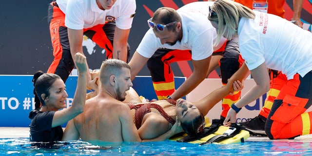 Anita Alvarez of the U.S. receives medical attention during the women's solo free final.
