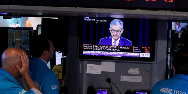 Traders look on as a screen shows Federal Reserve Chairman Jerome Powell's news conference after the U.S. Federal Reserve interest rates announcement on the floor of the New York Stock Exchange.