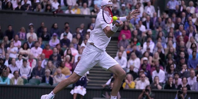 John Isner of the US returns the ball to Britain's Andy Murray during their singles tennis match on day three of the Wimbledon tennis championships in London, Wednesday, June 29, 2022. 
