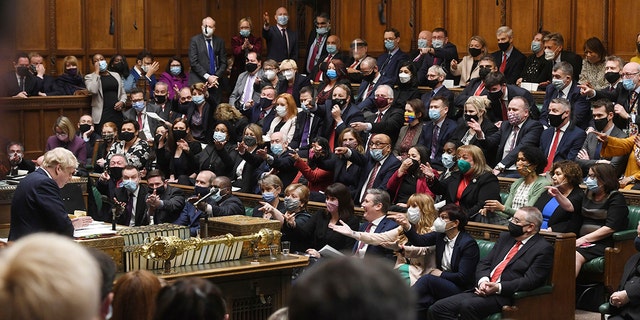 In this photo provided by UK Parliament, Britain's Prime Minister Boris Johnson speaks as members of the opposition party gesture, during Prime Minister's Questions in the House of Commons, in London, Wednesday, Jan. 12, 2022. 