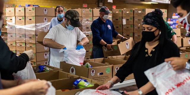Volunteers wearing protective masks bag groceries at a Catholic Charities Brooklyn and Queens pop-up food pantry in the Brooklyn borough of New York City in May 2020. The pandemic strained food banks and pantries.