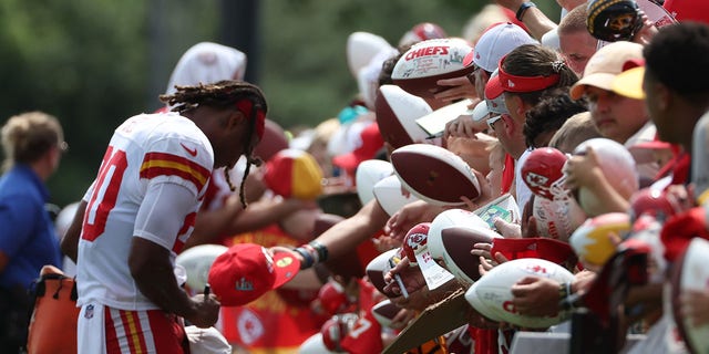 Fans hold footballs for safety Justin Reid (20) to sign after training camp Aug. 7, 2022, at Missouri Western State University in St. Joseph, Mo. 