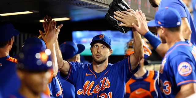 New York Mets starting pitcher Max Scherzer (21) high-fives teammates after the top of the seventh inning of the second game of a doubleheader against the Atlanta Braves, Aug. 6, 2022, in New York.