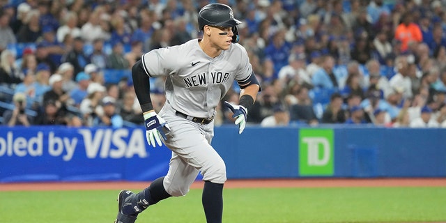 The New York Yankees' Aaron Judge runs to first after hitting a single to right field against the Toronto Blue Jays during first-inning baseball game action in Toronto, Monday, Sept. 26, 2022. 