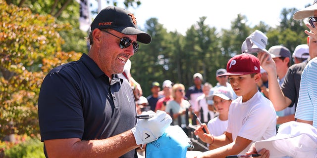 Team captain Phil Mickelson, of Hy Flyers GC, signs autographs for fans along the practice range during Day Three of the LIV Golf Invitational - Boston at The Oaks golf course at The International on Sept. 04, 2022 in Bolton, Massachusetts. 