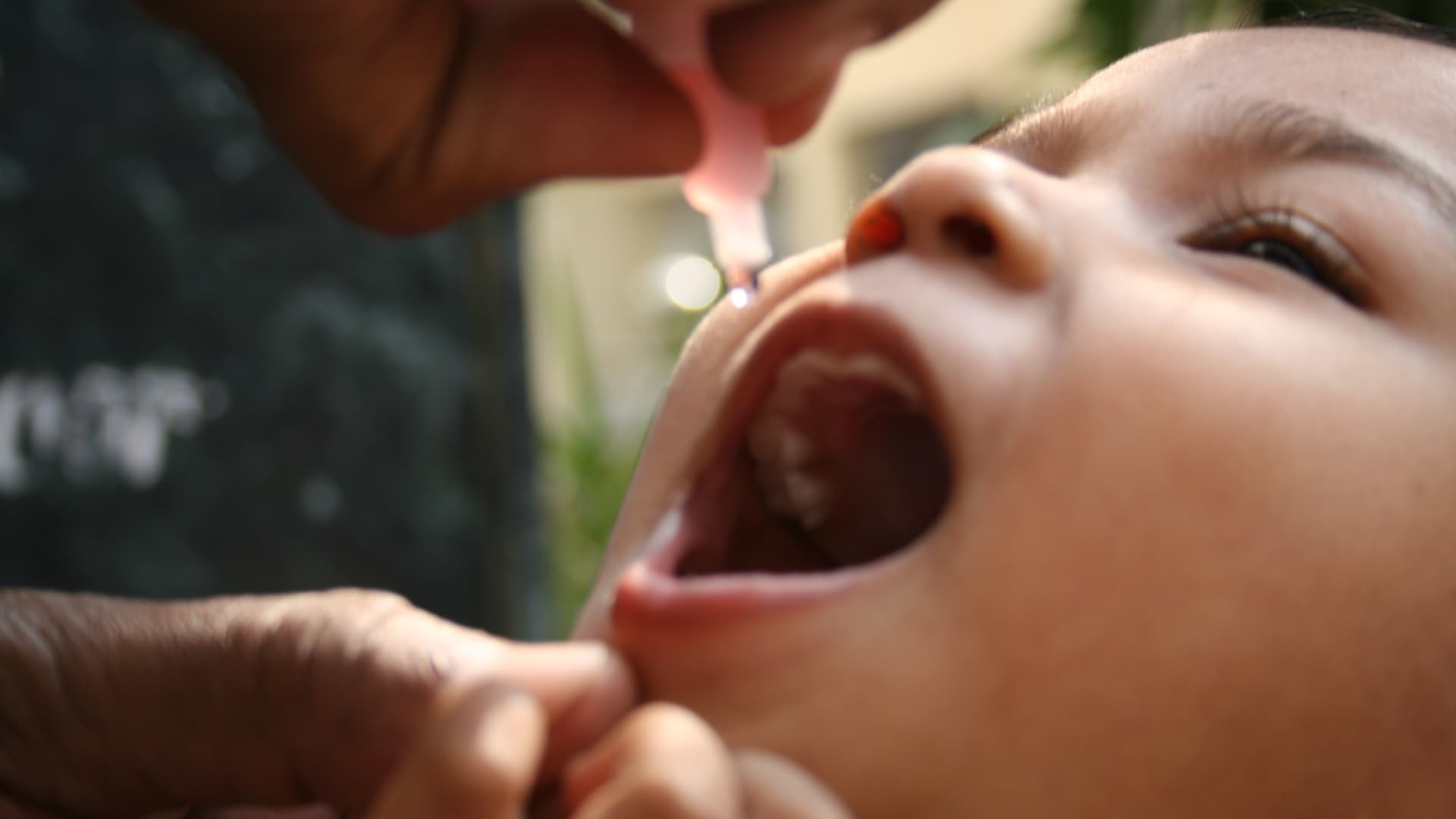 Girl receives anti-polio vaccination drops.