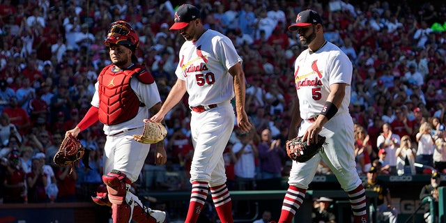 St. Louis Cardinals catcher Yadier Molina, left, starting pitcher Adam Wainwright (50) and first baseman Albert Pujols (5) walk off the field together as they are all removed at the from a baseball game against the Pittsburgh Pirates same time in the fifth inning Sunday, Oct. 2, 2022, in St. Louis. 