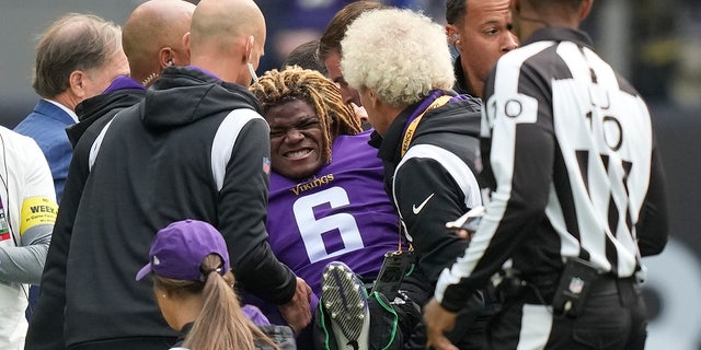 Minnesota Vikings safety Lewis Cine (6) grimaces as he receives treatment after an injury during an NFL match between Minnesota Vikings and New Orleans Saints at the Tottenham Hotspur stadium in London, Sunday, Oct. 2, 2022.