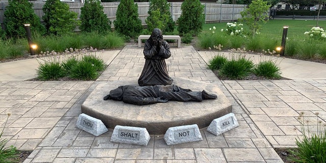 A statue in a Chicago neighborhood depicts Jesus grieving over the killing of an individual.