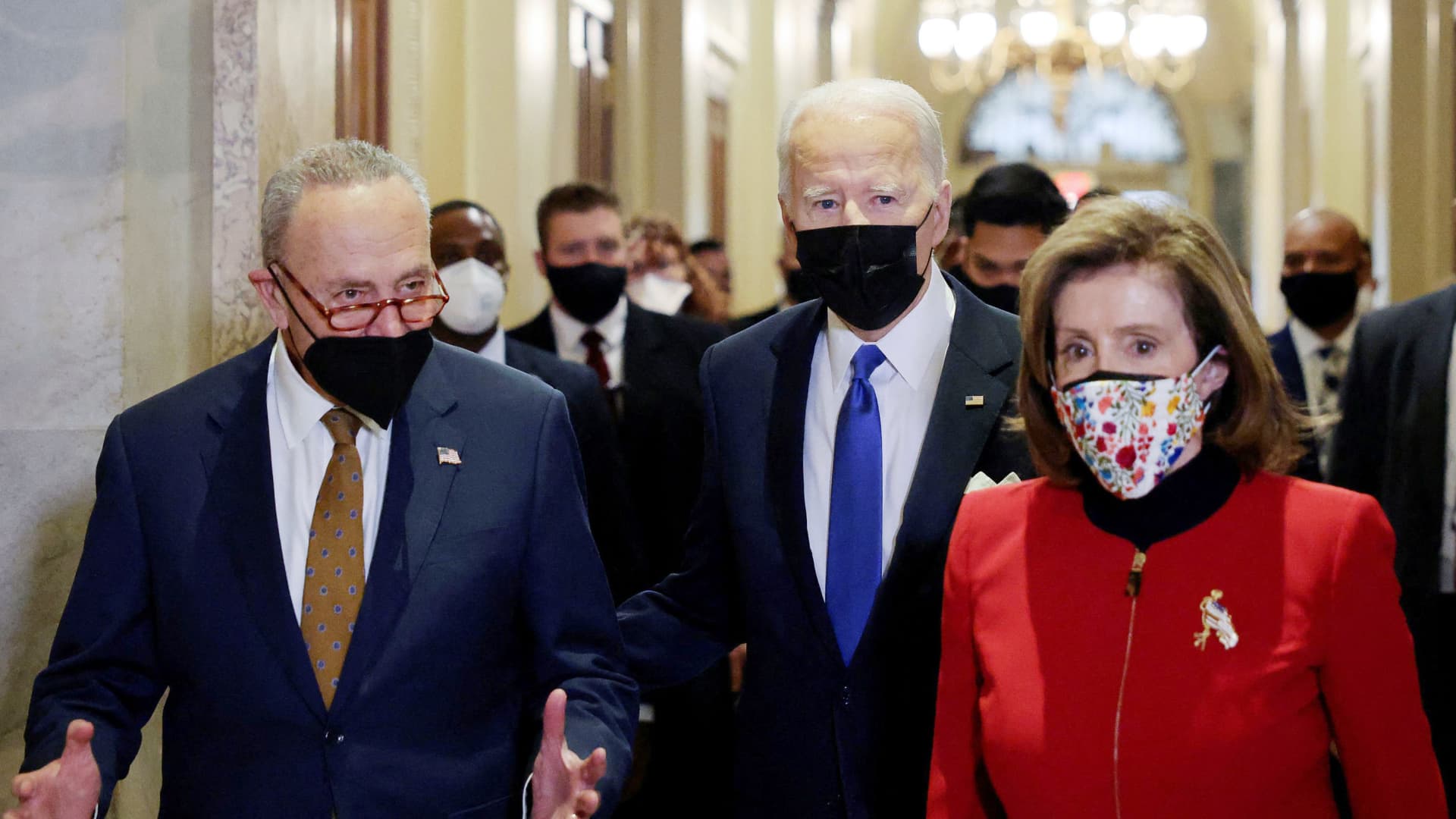 U.S. President Joe Biden is flanked by Senate Majority Leader Chuck Schumer (D-NY) and House Speaker Nancy Pelosi (D-CA) in the Hall of Columns as he arrives to mark the first anniversary of the January 6, 2021 attack on the U.S. Capitol by supporters of former President Donald Trump, on Capitol Hill in Washington, U.S., January 6, 2022.