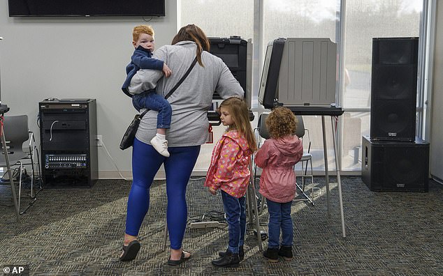 Before heading to preschool to drop off her children, Sydney Bailey votes on Election Day, in Avon, Ind.