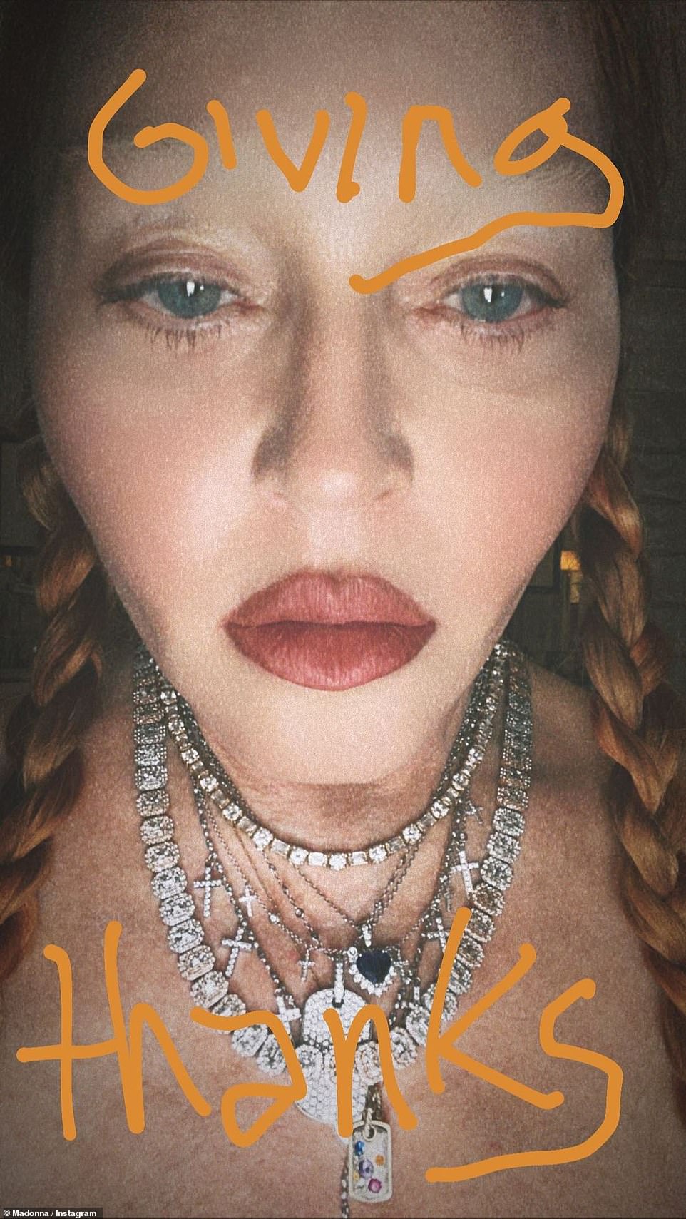 Giving thanks: Singer Madonna, 64, shared a flawless close-up of her face with orange writing spelling out 'giving thanks'
