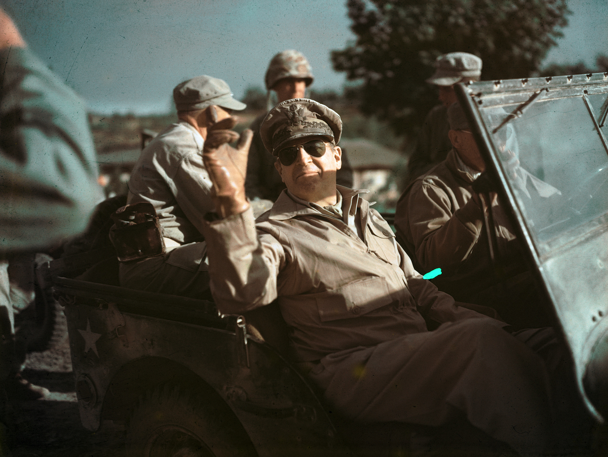 Color photo of General Douglas MacArthur riding in a jeep