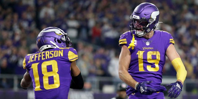 Minnesota Vikings wide receiver Adam Thielen (19) celebrates with teammate wide receiver Justin Jefferson (18) after catching a 15-yard touchdown pass during the second half of an NFL football game against the New England Patriots, Thursday, Nov. 24, 2022, in Minneapolis. 