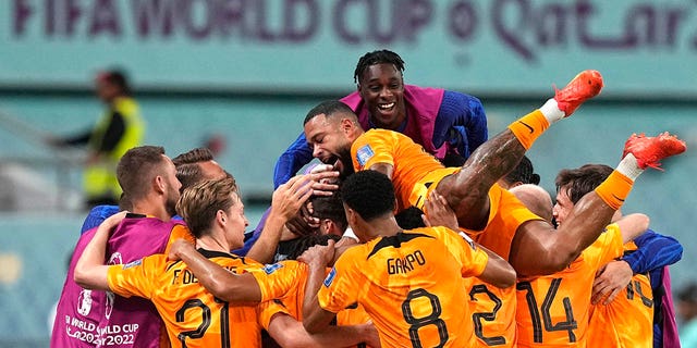 Netherlands players celebrate their second goal by Daley Blind during the World Cup match against the United States, at the Khalifa International Stadium, Saturday, Dec. 3, 2022.