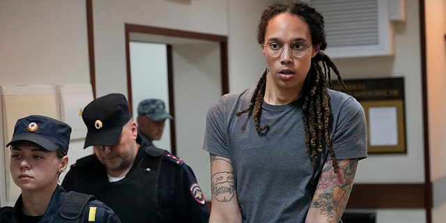 WNBA star and two-time Olympic gold medalist Brittney Griner is escorted from a courtroom after a hearing in Khimki just outside Moscow, Russia, Aug. 4, 2022.