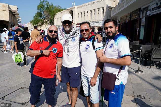 Fans pose for pictures in the streets of Doha hours before tonight's match between England and Senegal