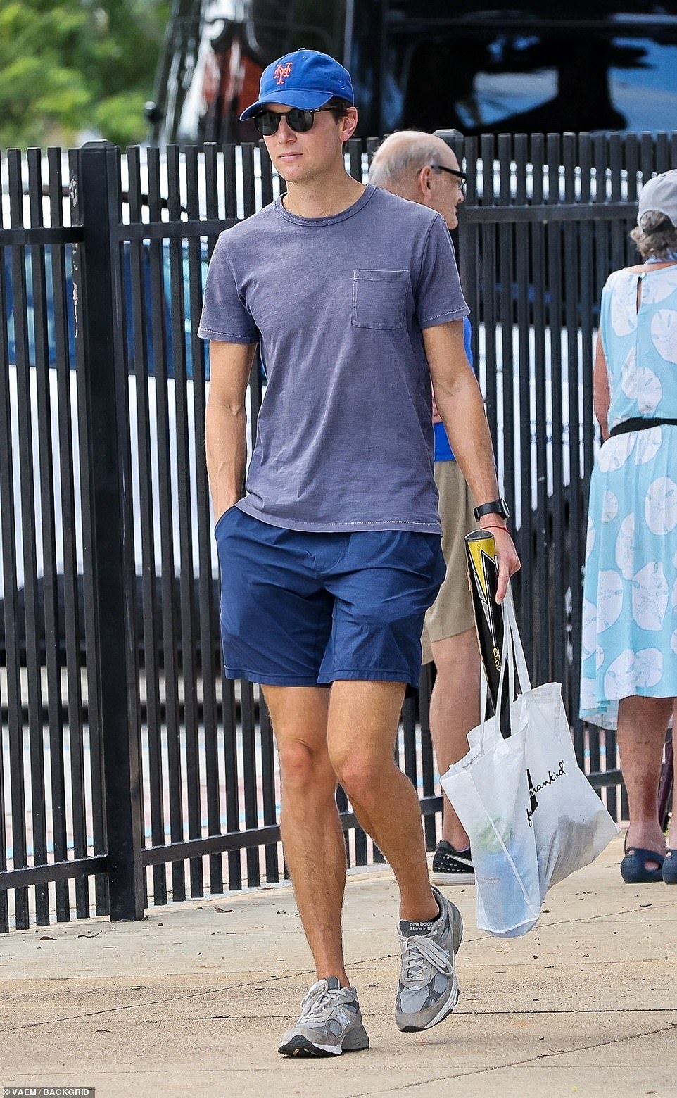 Jared was dressed casually in a faded purple pocket tee, navy shorts, and a pair of gray New Balance sneakers