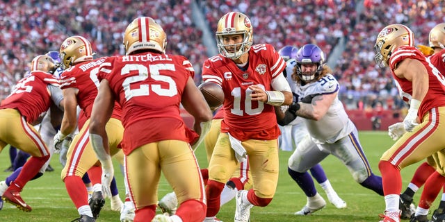San Francisco 49ers quarterback Jimmy Garoppolo (#10) hands the ball off to running back Eli Mitchell on Nov. 28, 2021. The NFL franchise's name and gold helmets are a tribute to the California Gold Rush of 1849.