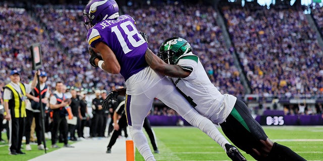 Justin Jefferson, #18 of the Minnesota Vikings, catches a touchdown pass while D.J. Reed, #4 of the New York Jets, defends during the fourth quarter at U.S. Bank Stadium on Dec. 4, 2022 in Minneapolis.
