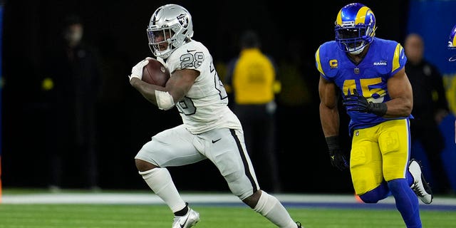 Las Vegas Raiders running back Josh Jacobs runs with the ball during the second half of an NFL football game against the Los Angeles Rams Thursday, Dec. 8, 2022, in Inglewood, California.