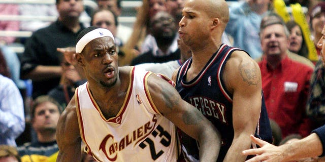 LeBron James (L) of the Cleveland Cavaliers posts up New Jersey Nets' Richard Jefferson during the fourth quarter of NBA play in Cleveland, Ohio, December 9, 2005.