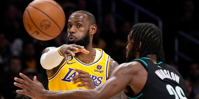 Los Angeles Lakers forward LeBron James, left, passes the ball as Portland Trail Blazers forward Justise Winslow defends during the first half of an NBA basketball game Wednesday, Nov. 30, 2022, in Los Angeles. 