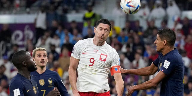 Poland's Robert Lewandowski heads the ball during the World Cup match against France at the Al Thumama Stadium in Doha, Qatar, Sunday, Dec. 4, 2022.