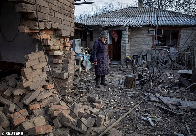 Local resident Yevheniia Yepifanova, 83, stands next to her house damaged by a Russian military strike, amid Russia's attack on Ukraine, in Chasiv Yar, Donetsk region today