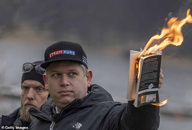 Rasmus Paludan is pictured burning the Koran outside of the Turkish embassy in Stockholm