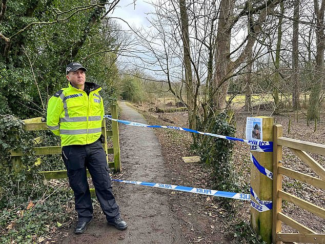An officer standing guard by a small mud path near to where Nicola Bulley disappeared