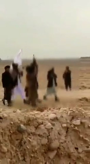 The group members then walk over, with one them holding up the damaged flag and pointing a gun towards it
