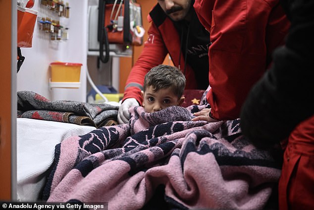 Pictured: Three-year-old Muhammed Yusuf Tanik receives medical help in an ambulance after the boy and his mother Fatma Tanik (not seen) were rescued by the search and rescue personnel from under the rubble of a collapsed building in Adiyaman, Turkiye