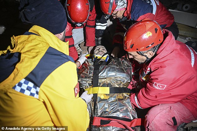 Pictured: Search and rescue teams carry a man who was pulled from under rubble of collapsed concrete building after 46 hours in Hatay, Turkey in the early hours on Wednesday