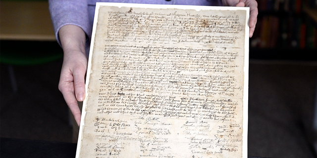 Connecticut Historical Society Collections Associate Julia Morrow displays an original complaint letter dated back to 1669 against Katherine Harrison, Tuesday, Jan. 31, 2023, in Hartford, Conn. Harrison, of Wethersfield, Conn. was tried multiple times for witchcraft.