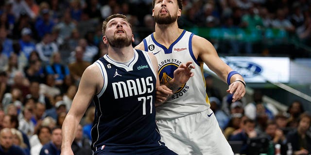 Luka Doncic, #77 of the Dallas Mavericks, and Klay Thompson, #11 of the Golden State Warriors, battle for position in the first half at American Airlines Center on March 22, 2023, in Dallas, Texas.