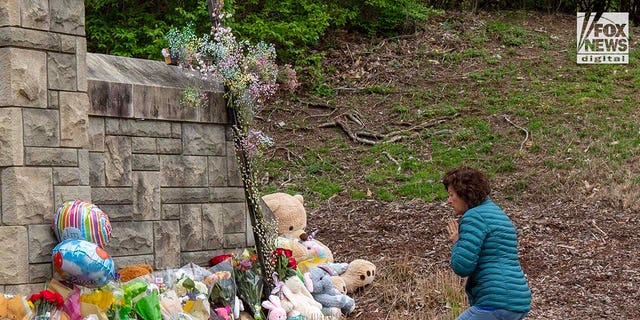 A mourner visits a memorial outside of The Covenant School for the six victims who were killed in a mass shooting in Nashville, Tennessee on Tuesday, March 28, 2023. On Monday, three adults and three children were killed inside the school.