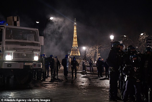 Riot police advance as clashes take place during a demonstration in Paris last night