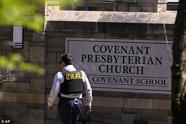 A police officer walks by an entrance to The Covenant School after a shooting in Nashville