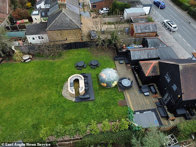 An aerial view of the back garden at Essex Stays, which features a patio, barbecue and hot tub