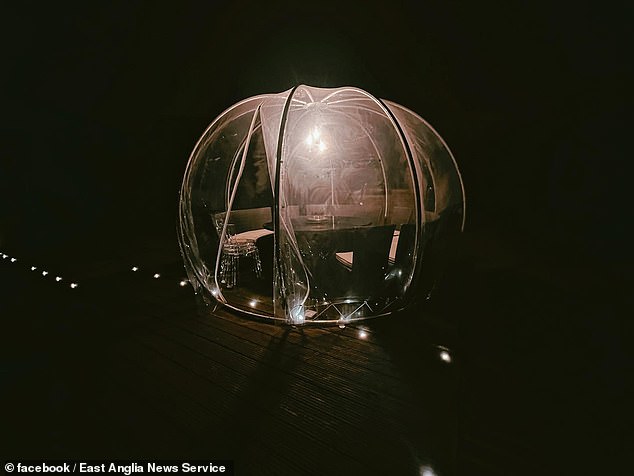 There is large see-through dining pod in the garden, currently filled with scatter cushions