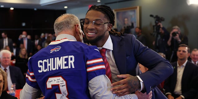 Senate Majority Leader Charles Schumer, left, greets Buffalo Bills safety Damar Hamlin at an event to introduce the Access to AEDs Act on March 29, 2023 in Washington, D.C.