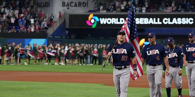 Mike Trout of the United States leads his teammates while carrying the American flag prior to a game against Japan at loanDepot Park March 21, 2023, in Miami, Fla. 