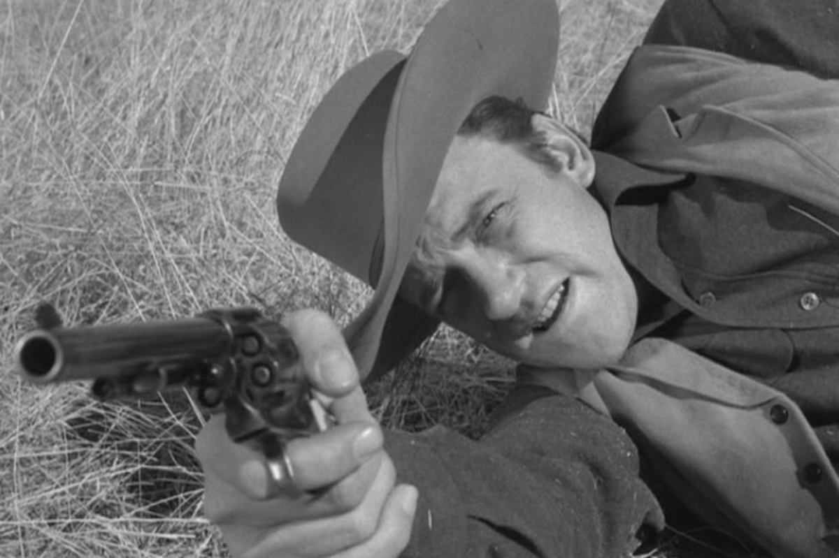 'Gunsmoke' 'Blue Horse' James Arness as Matt Dillon holding out his pistol, while laying on his side.