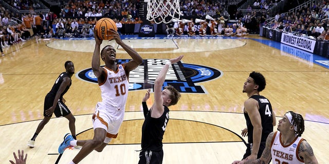 Sir'Jabari Rice, #10 of the Texas Longhorns, drives to the basket against Adam Kunkel, #5 of the Xavier Musketeers, during the first half in the Sweet 16 round of the NCAA Men's Basketball Tournament at T-Mobile Center on March 24, 2023, in Kansas City, Missouri.